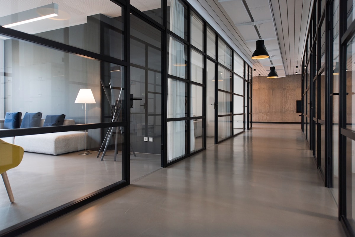 Modern glass office hallway with a quiet studio workspace